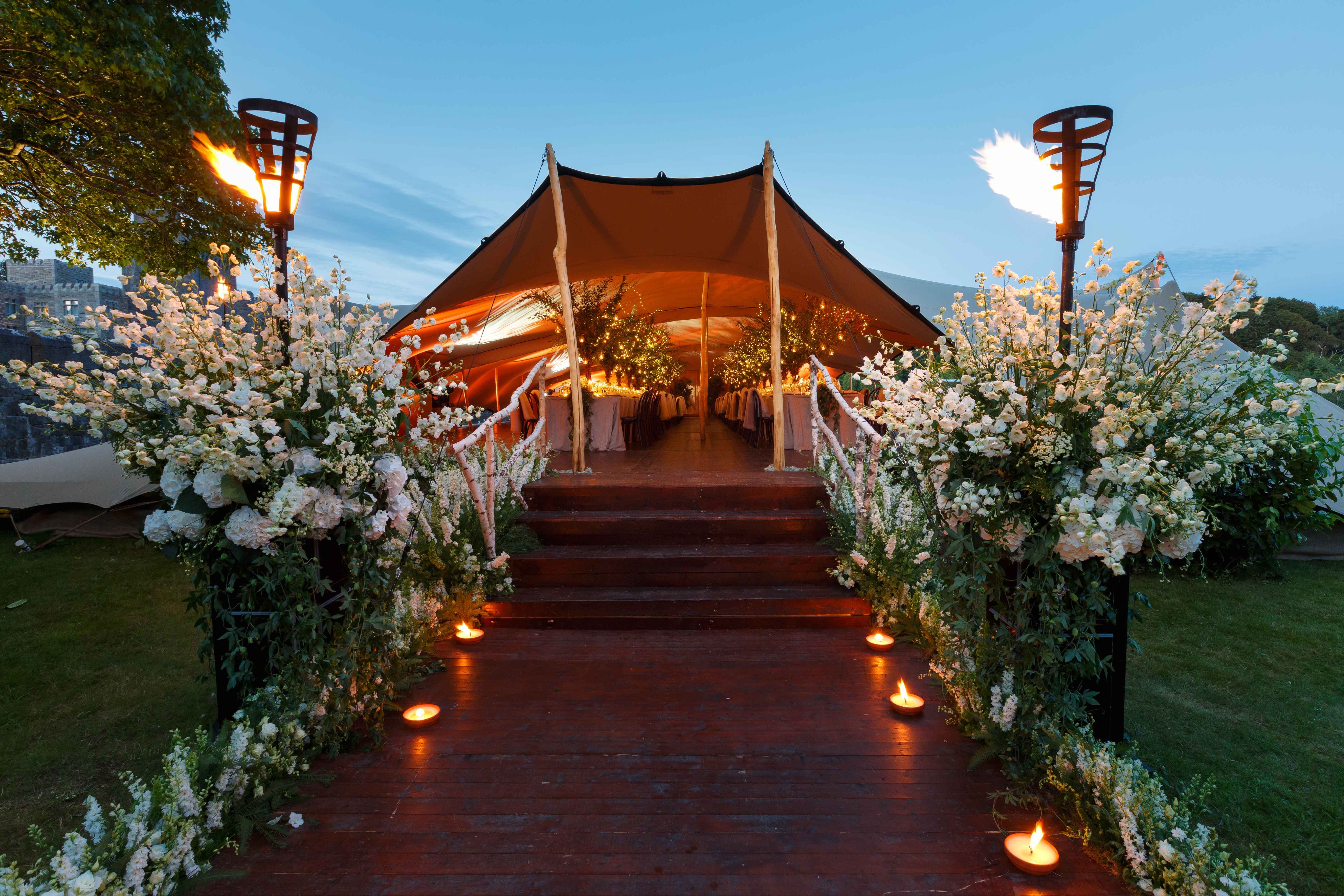 Outdoor wedding setting including canopy to host guests under