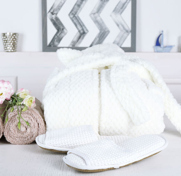 Bathrobe, towels and slippers on table, indoors A By Africa Studio Bathrobe, towels and slippers on table, indoors A By Africa Studio