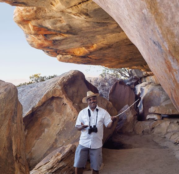 Bushmans Kloof Londi at the Cave pointing to rick art with a stick Bushmans Kloof Londi at the Cave pointing to rick art with a stick