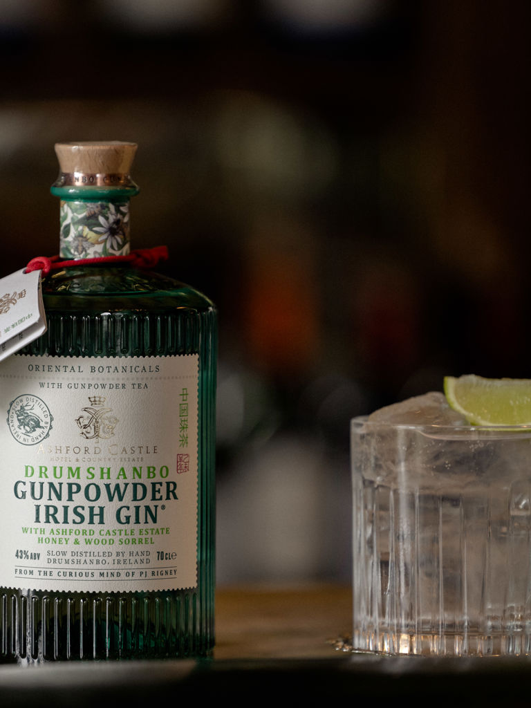 Bottle of Gunpowder Irish Gin along with glass of ice and lime Bottle of Gunpowder Irish Gin along with glass of ice and lime