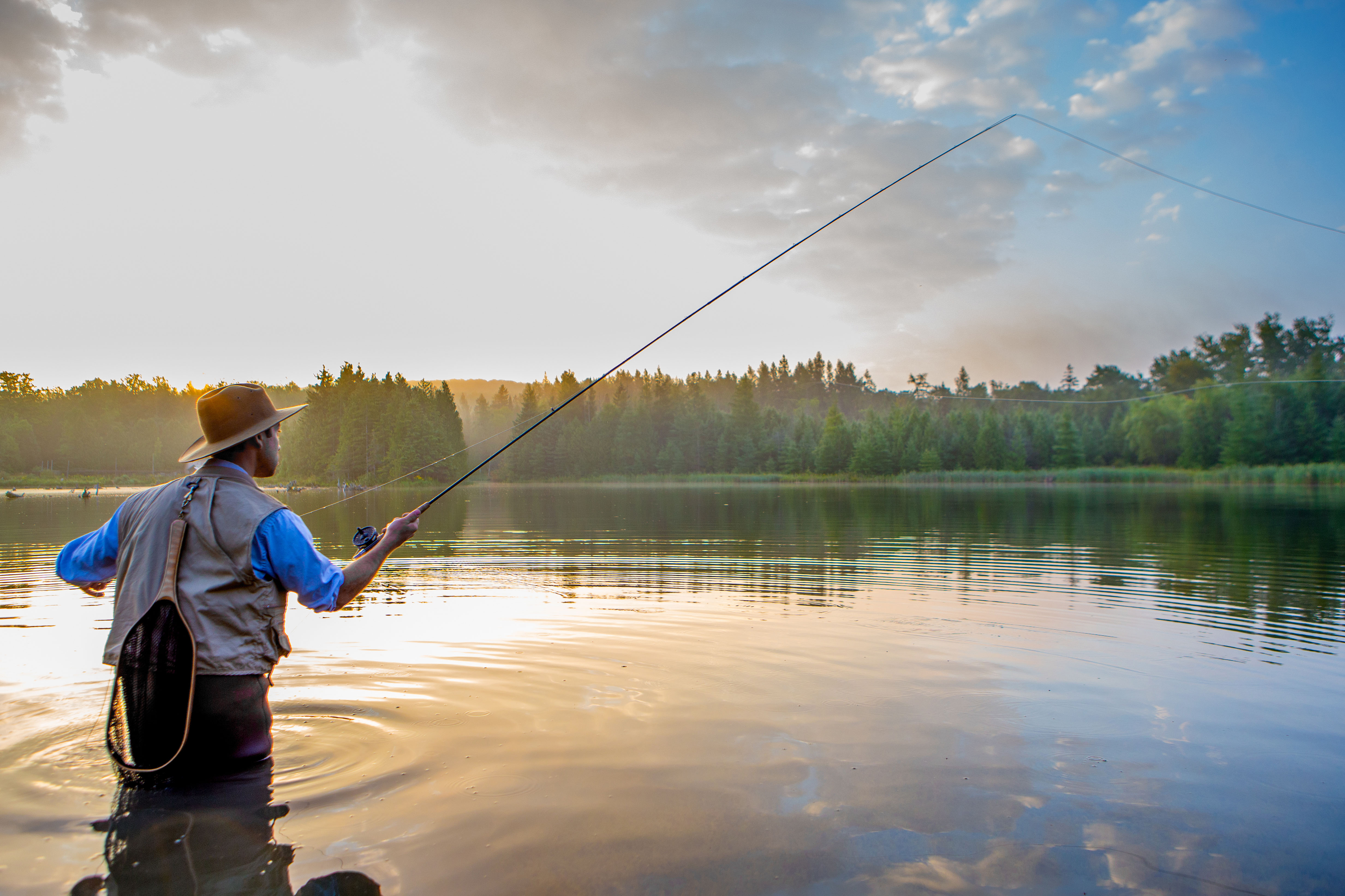 Young man flyfishing at sunrise