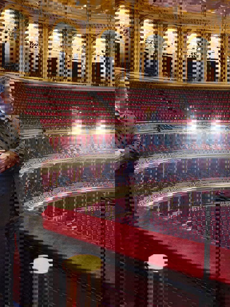 man standing in the amphitheatre stalls of the Royal Albert Hall man standing in the amphitheatre stalls of the Royal Albert Hall