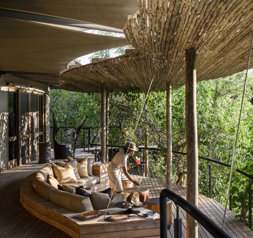 Xigera dining, waitress serving cocktails in the open lounge Xigera dining, waitress serving cocktails in the open lounge