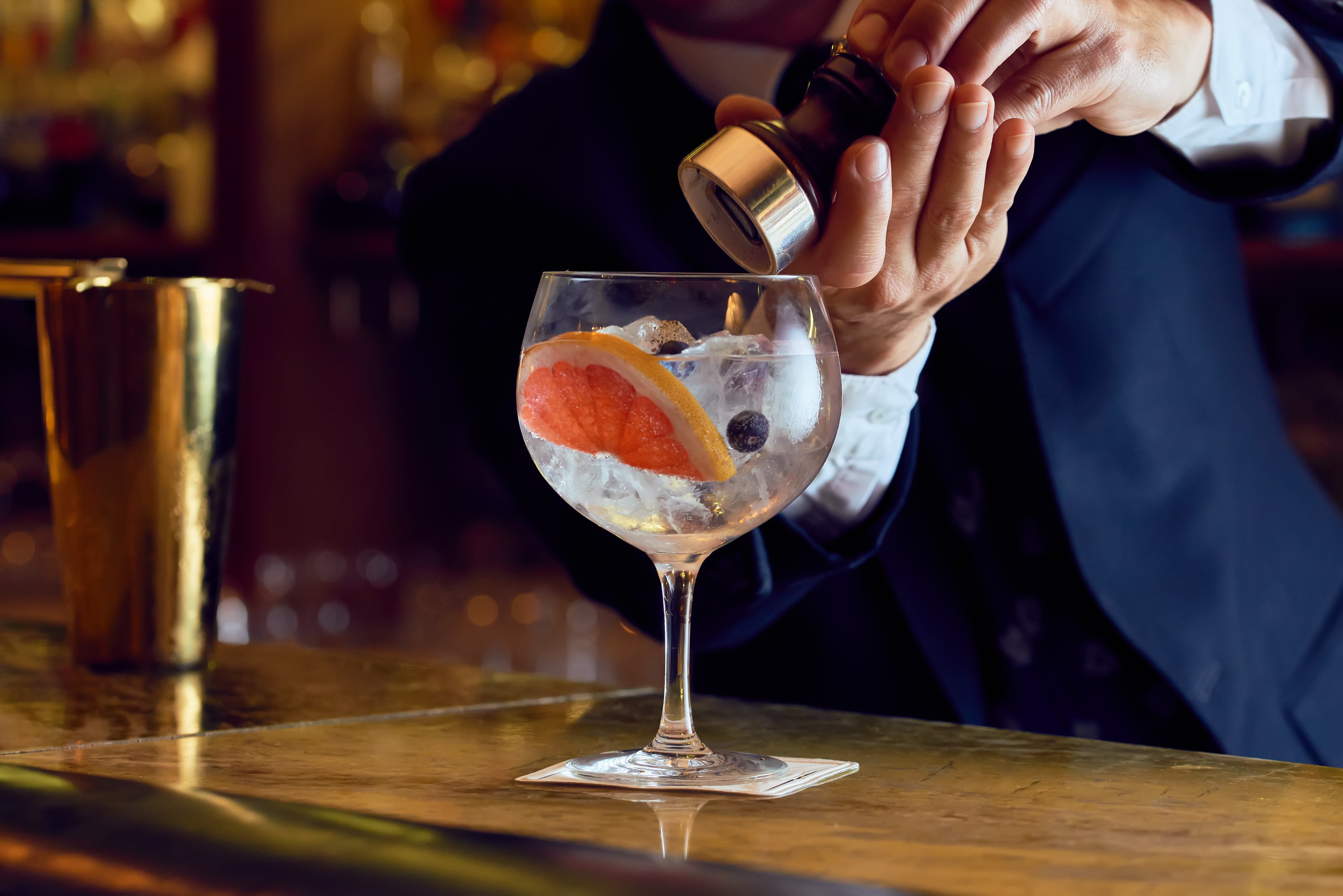 Barman pouring a gin cocktail
