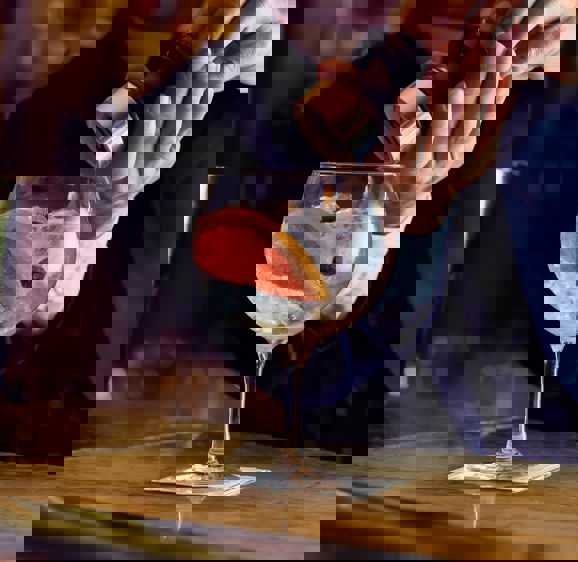 Barman pouring a gin cocktail Barman pouring a gin cocktail