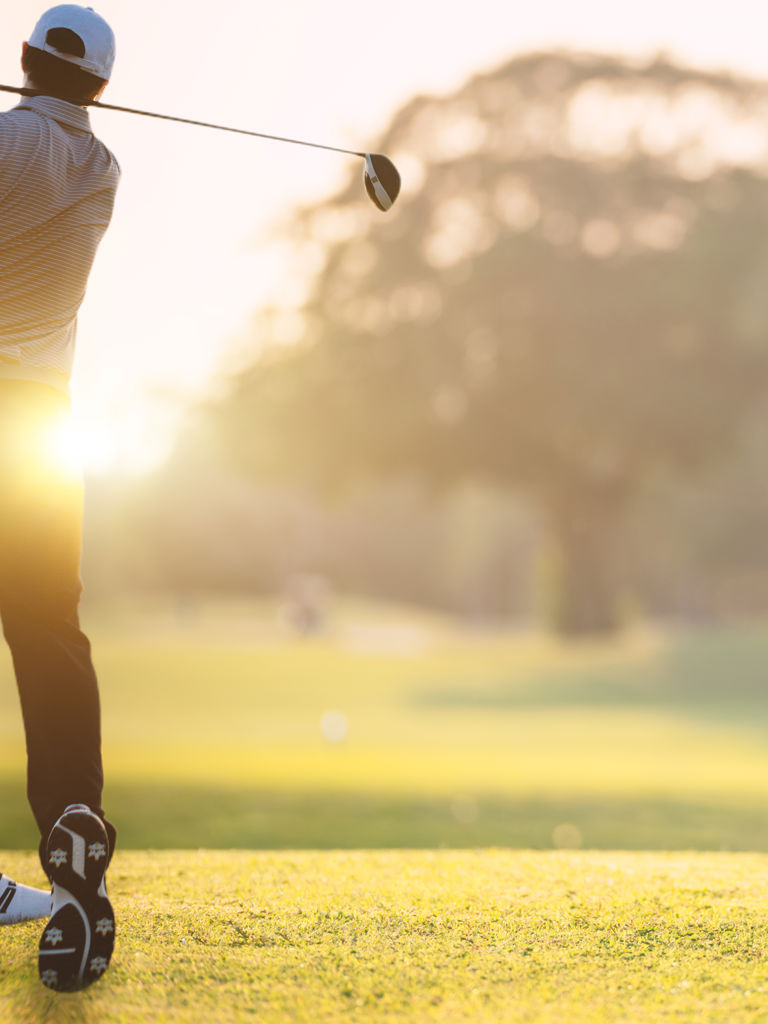 Golfer he's golfing in sunlight of the morning. View from the back. Chon Buri, Thailand Golfer he's golfing in sunlight of the morning. View from the back. Chon Buri, Thailand