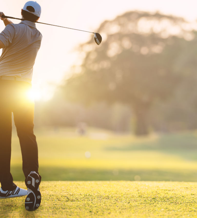 Golfer he's golfing in sunlight of the morning. View from the back. Chon Buri, Thailand Golfer he's golfing in sunlight of the morning. View from the back. Chon Buri, Thailand