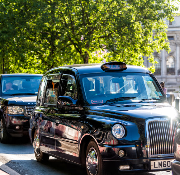 Expensive black taxi cab and drivers on street road waiting in traffic in downtown summer Expensive black taxi cab and drivers on street road waiting in traffic in downtown summer