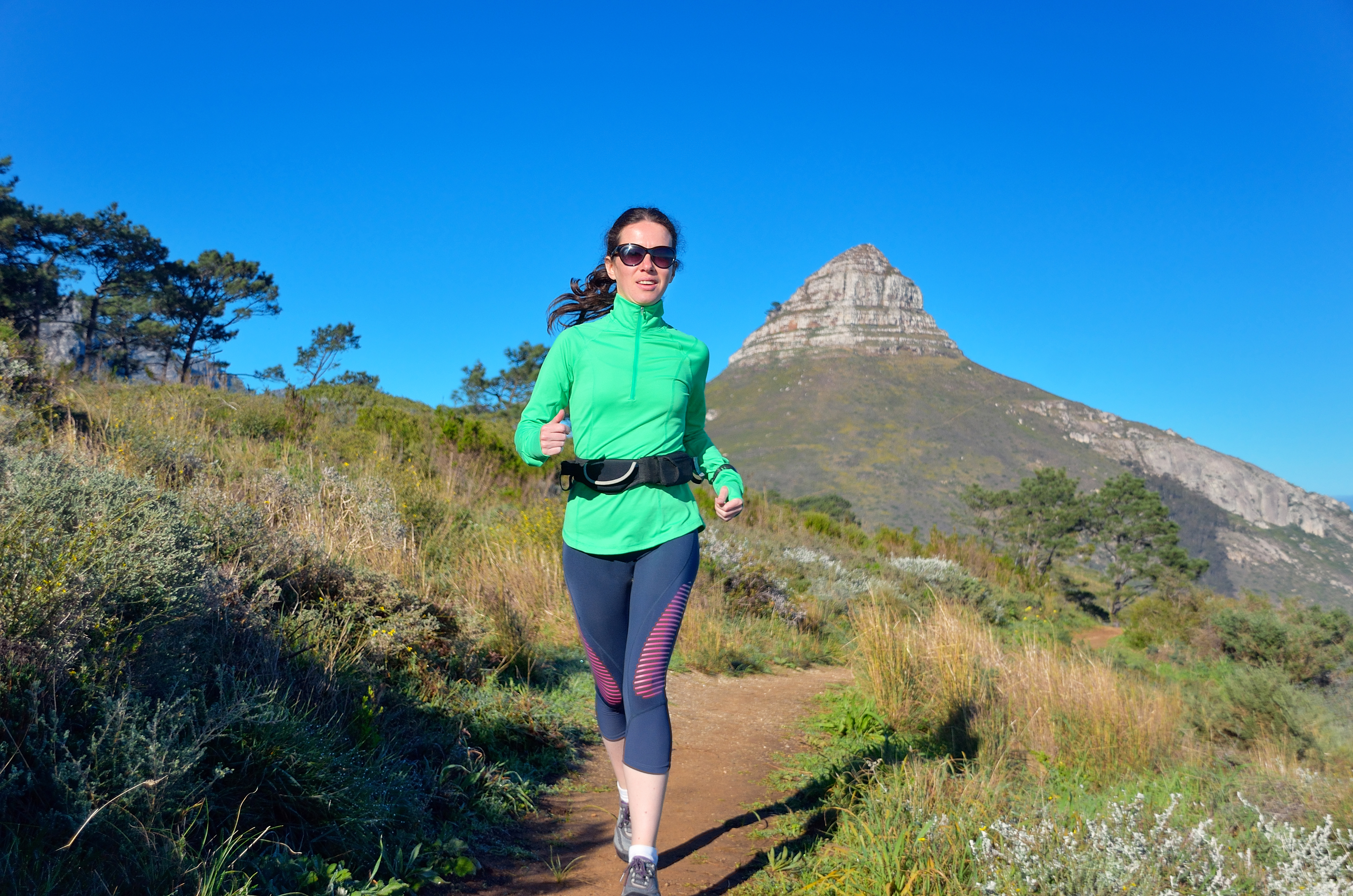 Active woman runner runs trail near Table mountain, Cape Town, South Africa. Running and fitness concept