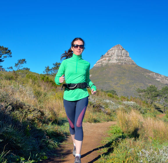 Active woman runner runs trail near Table mountain, Cape Town, South Africa. Running and fitness concept Active woman runner runs trail near Table mountain, Cape Town, South Africa. Running and fitness concept