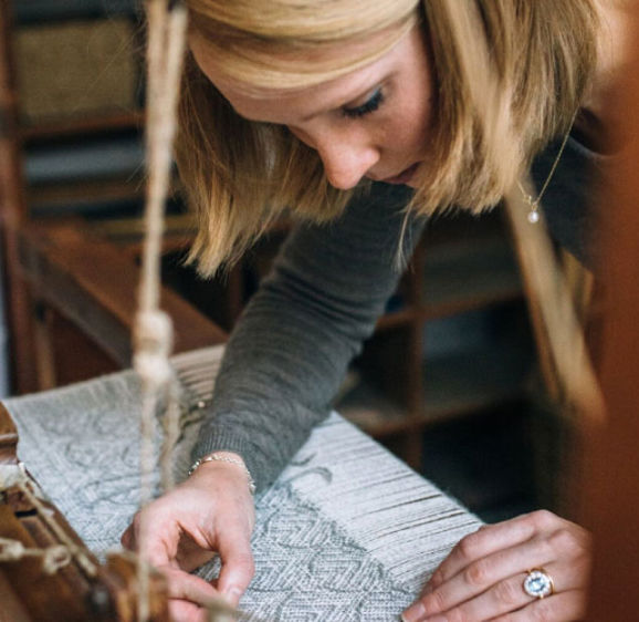 Woman at weaving table Woman at weaving table