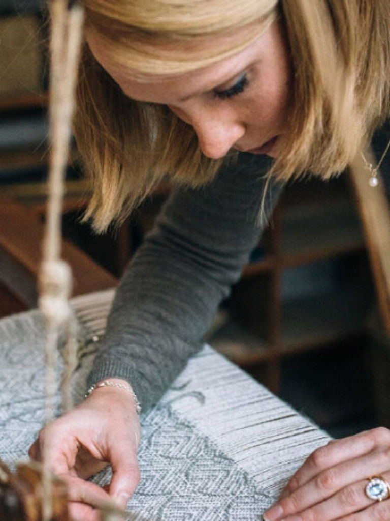 Woman at weaving table Woman at weaving table