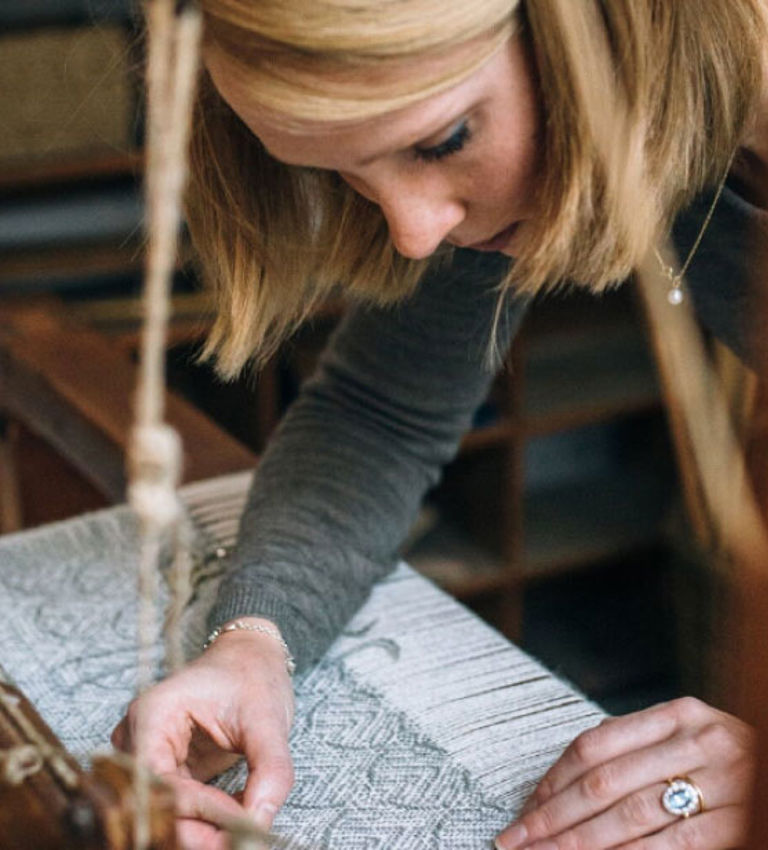 Woman at weaving table Woman at weaving table