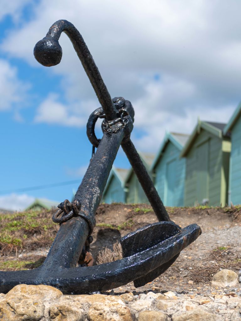 Photo of the anchor at Charmouth beach with beach huts in the background Charmouth, Bridport Photo of the anchor at Charmouth beach with beach huts in the background Charmouth, Bridport
