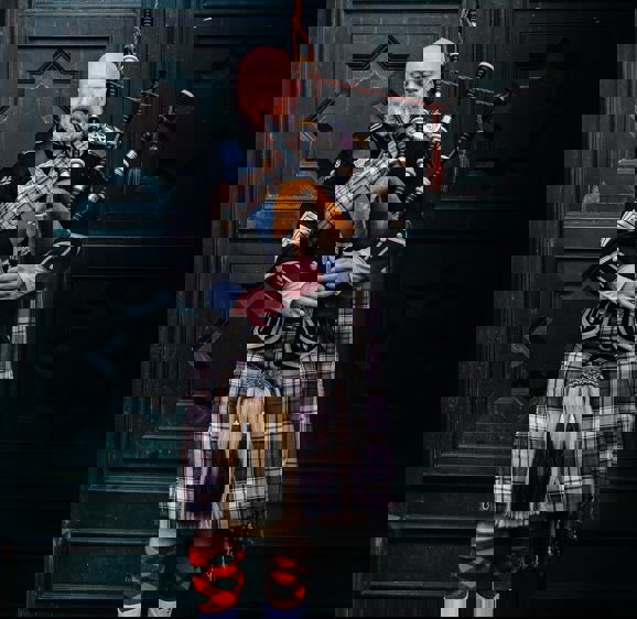 Scottish Man Wearing A Kilt Playing Bagpipes Scottish Man Wearing A Kilt Playing Bagpipes