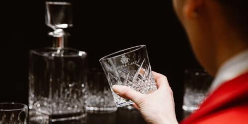 Waterford Crystal glass being held with a decanter in the background