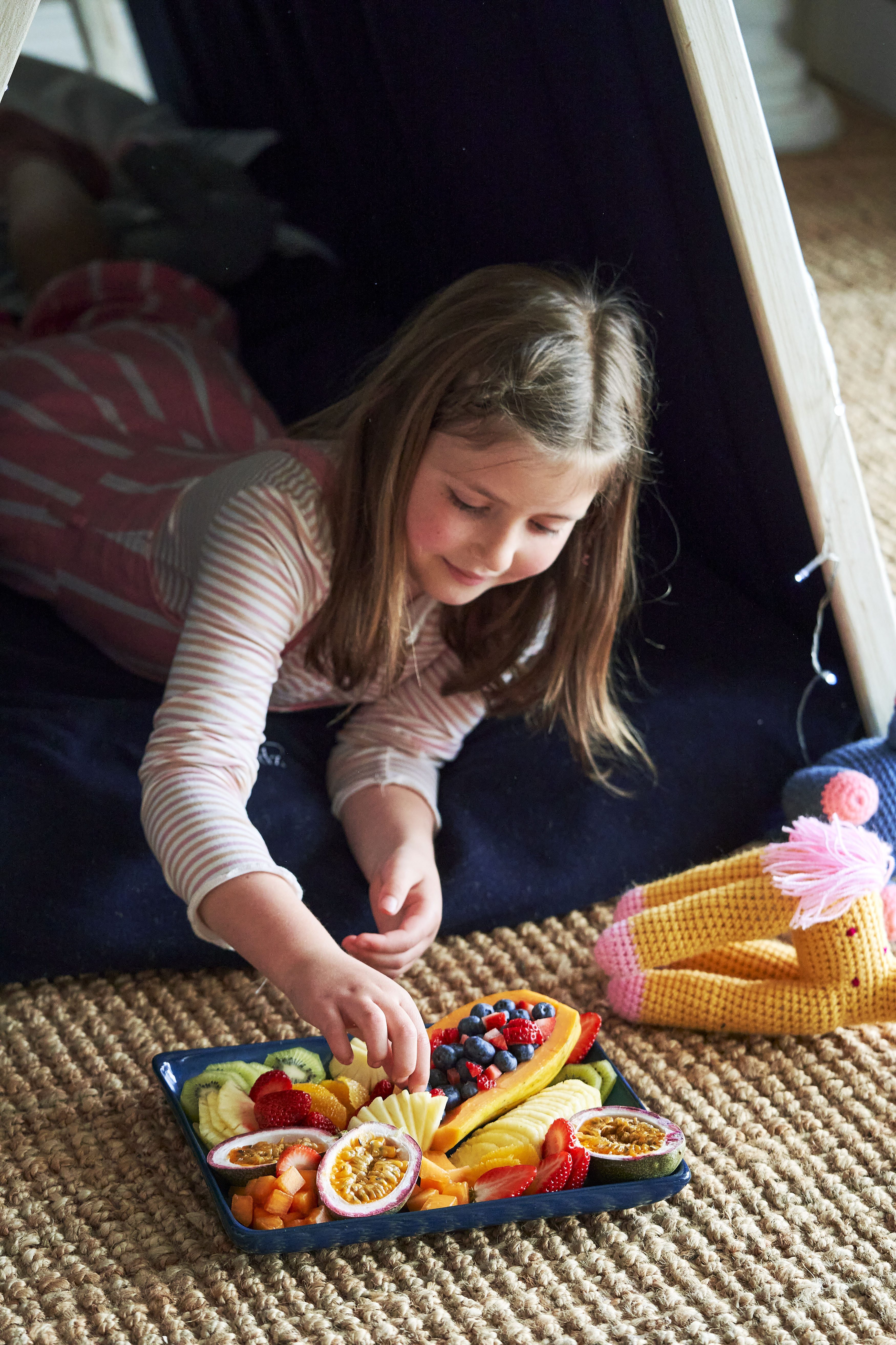 Girl in Wigwam eating fruit