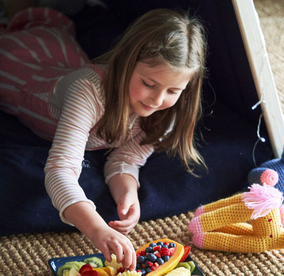 Girl in Wigwam eating fruit Girl in Wigwam eating fruit