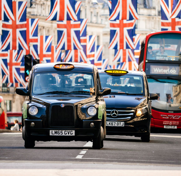 Taxi cabs and buses under Union Jack Flags on Regent Street Taxi cabs and buses under Union Jack Flags on Regent Street
