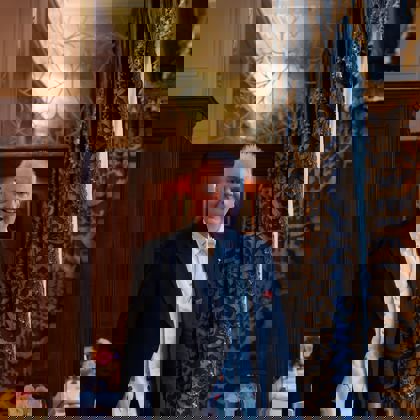 Robert Bowe standing in the restaurant in front of a drape Robert Bowe standing in the restaurant in front of a drape