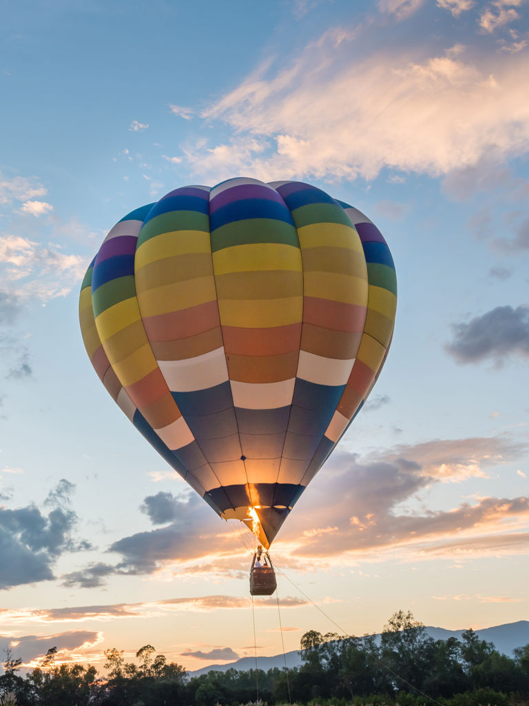Hot air balloon is flying at sunrise Hot air balloon is flying at sunrise