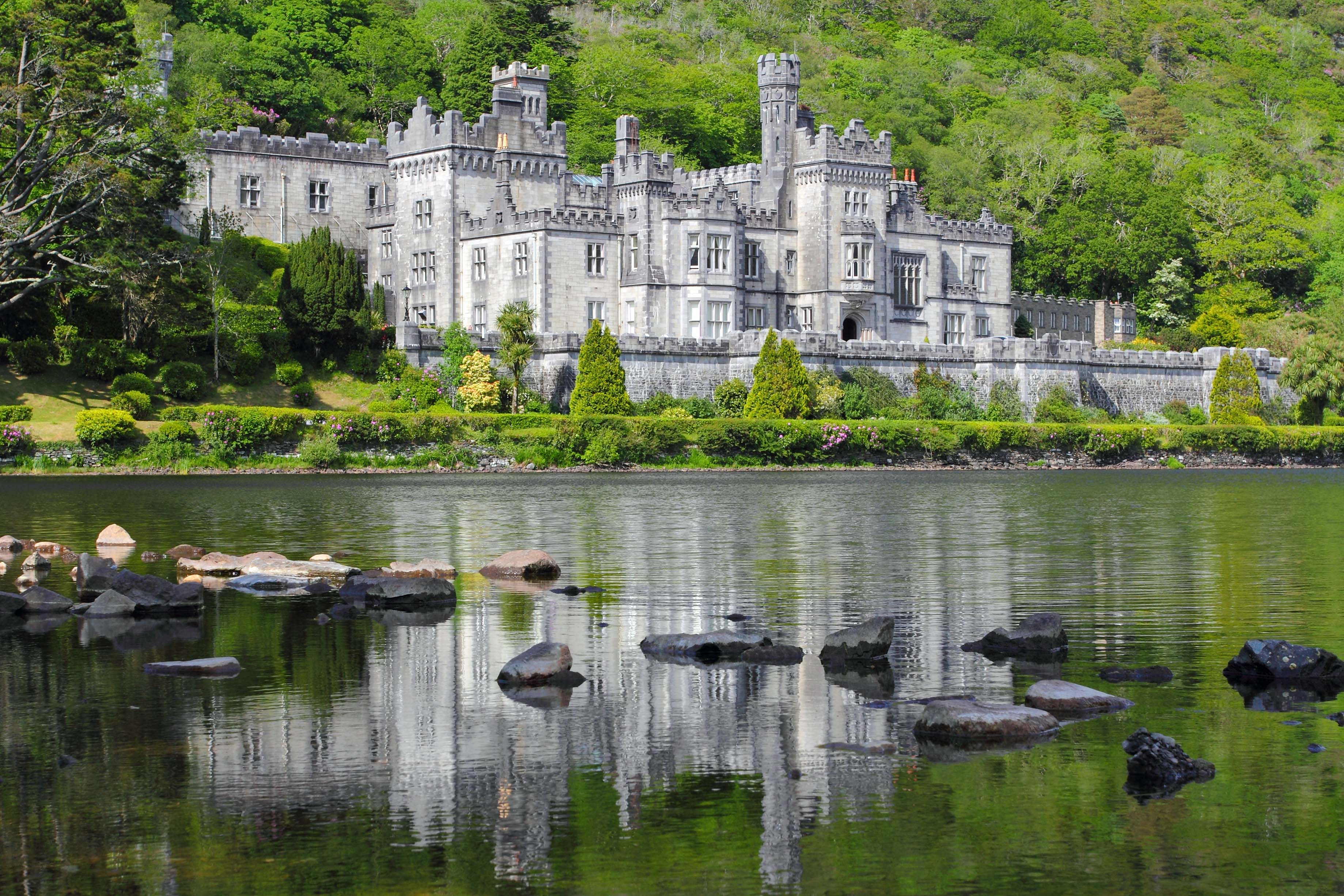 Kylemore Abbey reflected in green water lake , Mayo county , Ireland