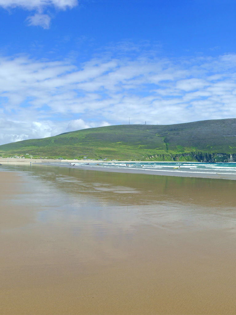 A panorama view of Keel Beach and holiday makers enjoying the summer sun, looking towards Dooega Head, Achill Island, County Mayo, Ireland A panorama view of Keel Beach and holiday makers enjoying the summer sun, looking towards Dooega Head, Achill Island, County Mayo, Ireland
