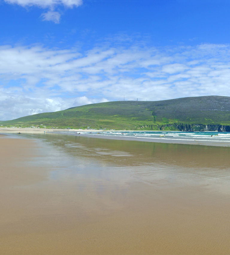A panorama view of Keel Beach and holiday makers enjoying the summer sun, looking towards Dooega Head, Achill Island, County Mayo, Ireland A panorama view of Keel Beach and holiday makers enjoying the summer sun, looking towards Dooega Head, Achill Island, County Mayo, Ireland